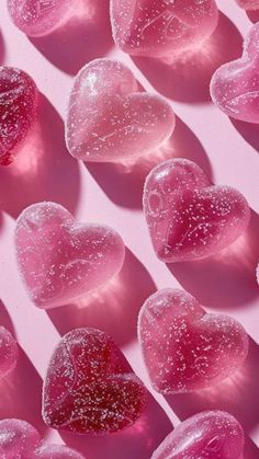 pink hearts are arranged in the shape of water droplets on a pink background with white and red highlights