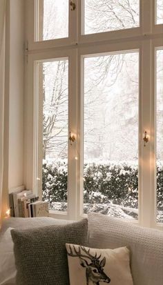 a living room filled with furniture and windows covered in snow