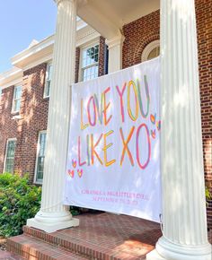 a sign that says love you like xo on the side of a building with columns