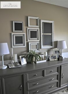 a living room with pictures on the wall and a sideboard in front of it