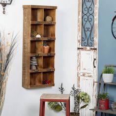 an old wooden shelf with several pots and plants on it next to a wall clock