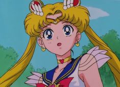 a woman with long blonde hair and big blue eyes wearing a sailor outfit in front of trees