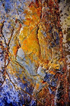 an abstract painting with orange and blue colors on the rocks in front of it's surface