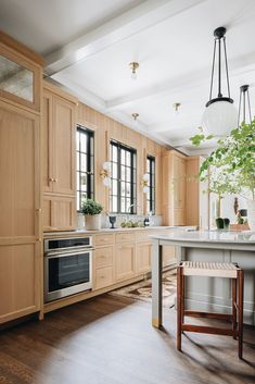 a large kitchen with wooden cabinets and an island in front of the stove top oven