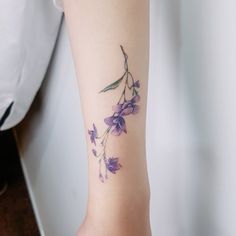 a woman's arm with purple flowers on it