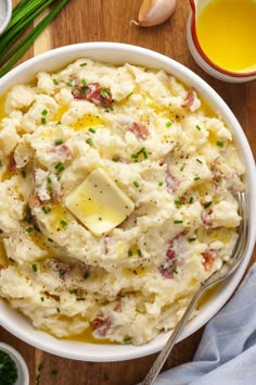 mashed potatoes with butter and parmesan cheese in a white bowl on a wooden table