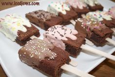 chocolate brownies with ice cream and sprinkles are on a white plate