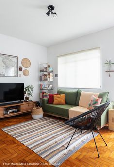 a living room filled with furniture and a flat screen tv on top of a wooden floor