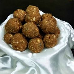 a pile of food sitting on top of a white cloth next to a bowl filled with meatballs