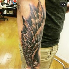 a man's arm with an eagle tattoo on it, in the middle of a room