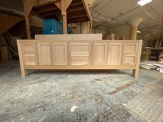 a large wooden cabinet sitting on top of a hard wood floor in a room filled with unfinished furniture