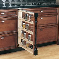 a kitchen cabinet with pull out spice rack