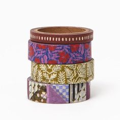 four different colored washi tapes stacked on top of each other in various patterns and sizes