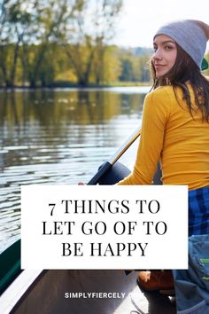 a woman in a canoe with the words 7 things to let go of to be happy