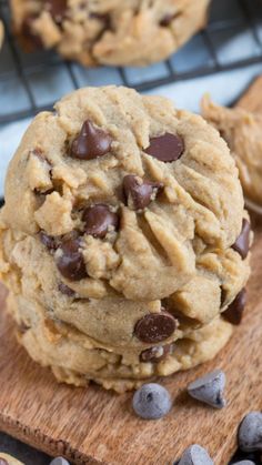 chocolate chip cookies on a wooden board with cooling rack in the backgrouf