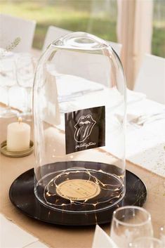 the rolling stones logo under a glass clochet on a table with candles and place cards