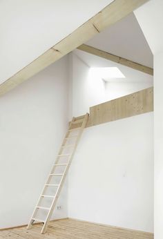 an empty room with a ladder to the ceiling