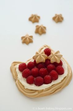 there is a dessert with raspberries on it and icing around the edges