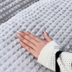 a woman's hand on top of a white blanket