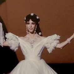 a woman in a white wedding dress with her arms outstretched