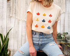 Introducing Our Maple Leaf T-Shirt: Celebrate the Colors of Fall 🍁 Product Details:     Color: Cream     Material: 100% Airlume combed and ring-spun cotton for a soft and comfortable feel.     Fabric Weight: 4.2 oz./yd.² (142 g/m offering a cozy and lightweight fit.     Fit: Regular fit designed to provide all-day comfort.     Construction: Side-seamed for a stylish and tailored appearance.     Neckline: Classic crew neck with a coverstitched collar for added durability.     Tag: Tear-away tag for a smooth, tag-free wearing experience. 🍂 Embrace the Essence of Fall: Our Maple Leaf T-Shirt brings the vibrant colors of fall to your wardrobe. Featuring a beautiful leaf collage design, this shirt captures the essence of autumn's natural beauty. Perfect for those who love the changing seasons Leaf Shirt, Leaf Collage, Colors Of Fall, Collage Design, Fall Shirt, Nature Inspired Design, Fall Shirts, Changing Seasons, Maple Leaf