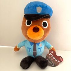 a brown teddy bear wearing a blue hat and uniform with a tag on it's chest