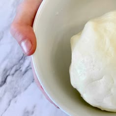 hands mixing butter in a bowl with a whisk and other ingredients around it