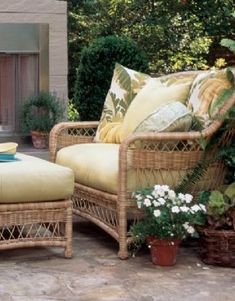 an outdoor patio with wicker furniture and potted plants