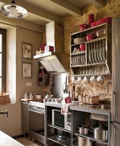 a kitchen with lots of pots and pans on the shelves above the stove top