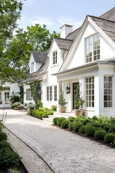 a white house with lots of windows and plants