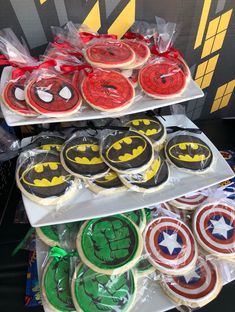 decorated cookies in the shape of batman and captain america are on display at a children's birthday party