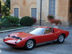 a red sports car parked in front of a building