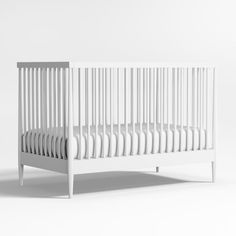 a white crib is shown against a white background with no one in the room