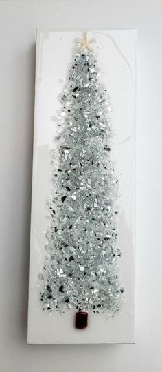 a white christmas tree with silver tinsel on it