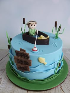 a birthday cake with a man in a boat on the water