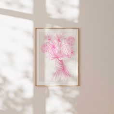 a pink and white drawing hanging on the wall next to a vase with flowers in it