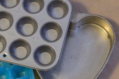 a metal muffin pan sitting on top of a table next to an ice tray