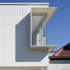 the corner of a white building with a red roof