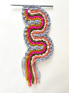 a crochet piece with an odd shaped design on it and a knitting needle in the middle