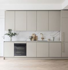 a kitchen with white cabinets and marble counter tops