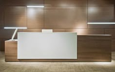 an empty reception area with lights on the wall and wood paneled walls behind it