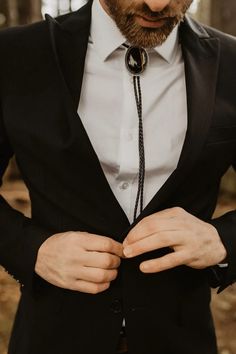 a man wearing a black suit and tie