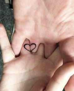 two hands are holding small hearts in the shape of a heart on their palms