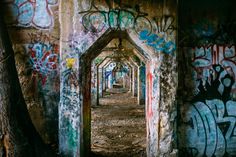 an old tunnel with graffiti all over it