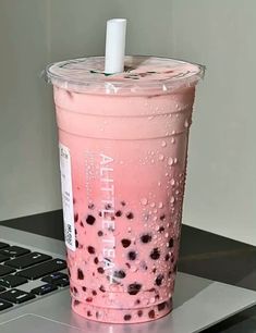 a pink drink sitting on top of a laptop computer