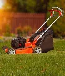 an orange lawn mower sitting in the grass