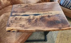 a wooden table sitting on top of a brown couch