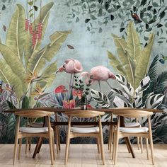 two pink flamingos standing in front of a wall mural with tropical plants and butterflies