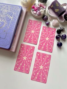 four pink playing cards sitting on top of a table next to some candy and other items