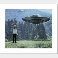 a man standing in the grass looking at an alien ship flying over him and another person watching